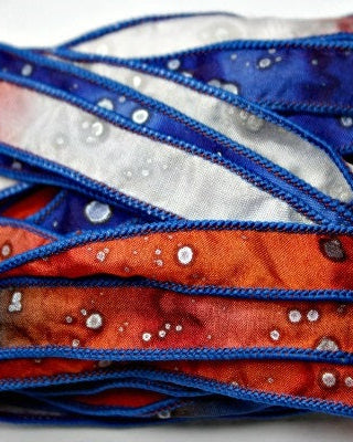 A bundle of silk wrap ribbons in red, white, and blue colors with a crinkled texture, tied together.